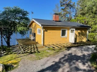 Gul stuga med altanbygge