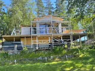 Hus med byggnadsställning vid sjötomt