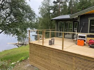 Trädäck med räcke vid sjötomt
