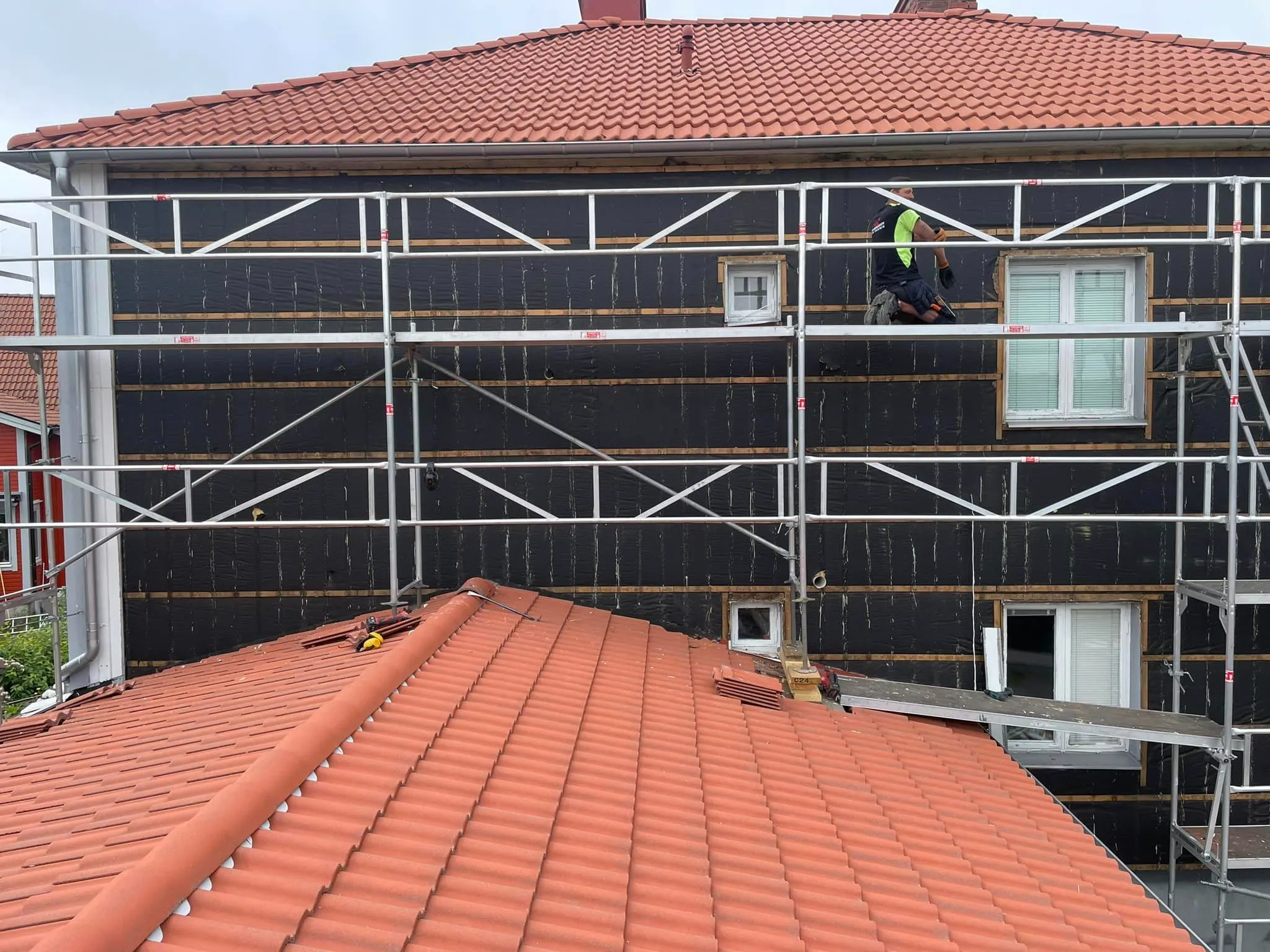 Fasadrenovering med byggnadsställning och nytt tegeltak