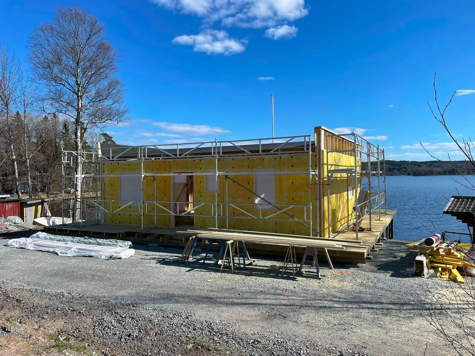 Fasadarbete med vindskyddsskivor vid sjön
