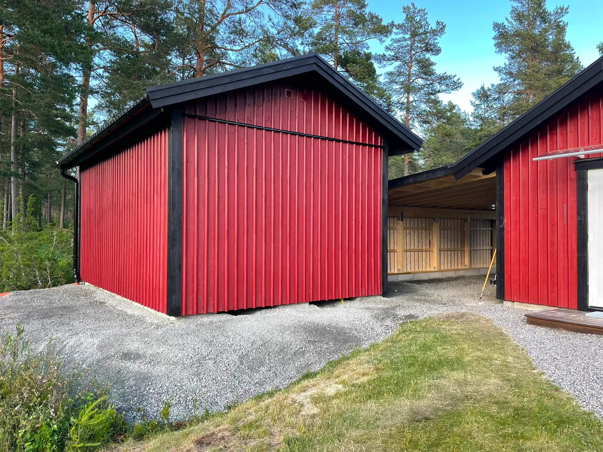 Nymålade faluröda uthus med svarta plåttak