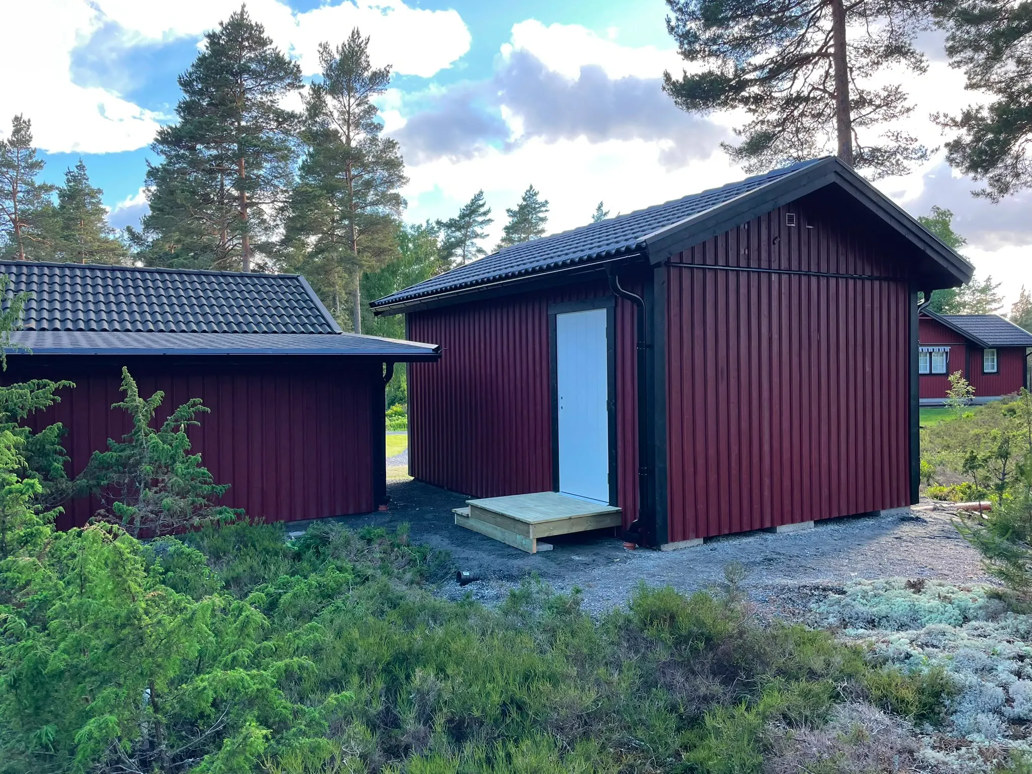 Nybyggt falurött förråd med svart plåttak